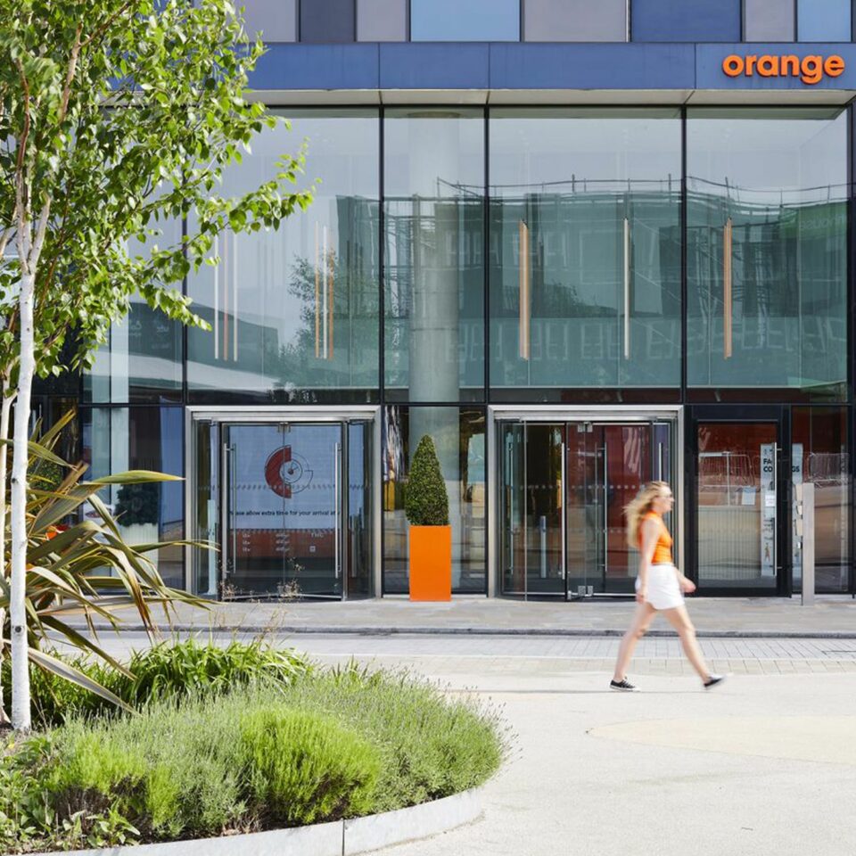 Women walking past the Orange building entrance