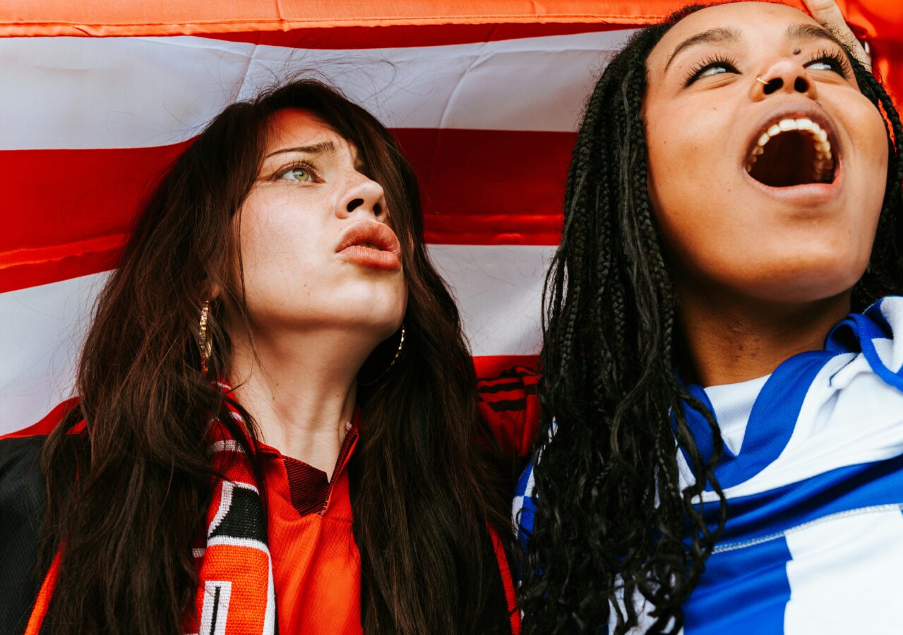 two people looking away from the camera reacting to the football
